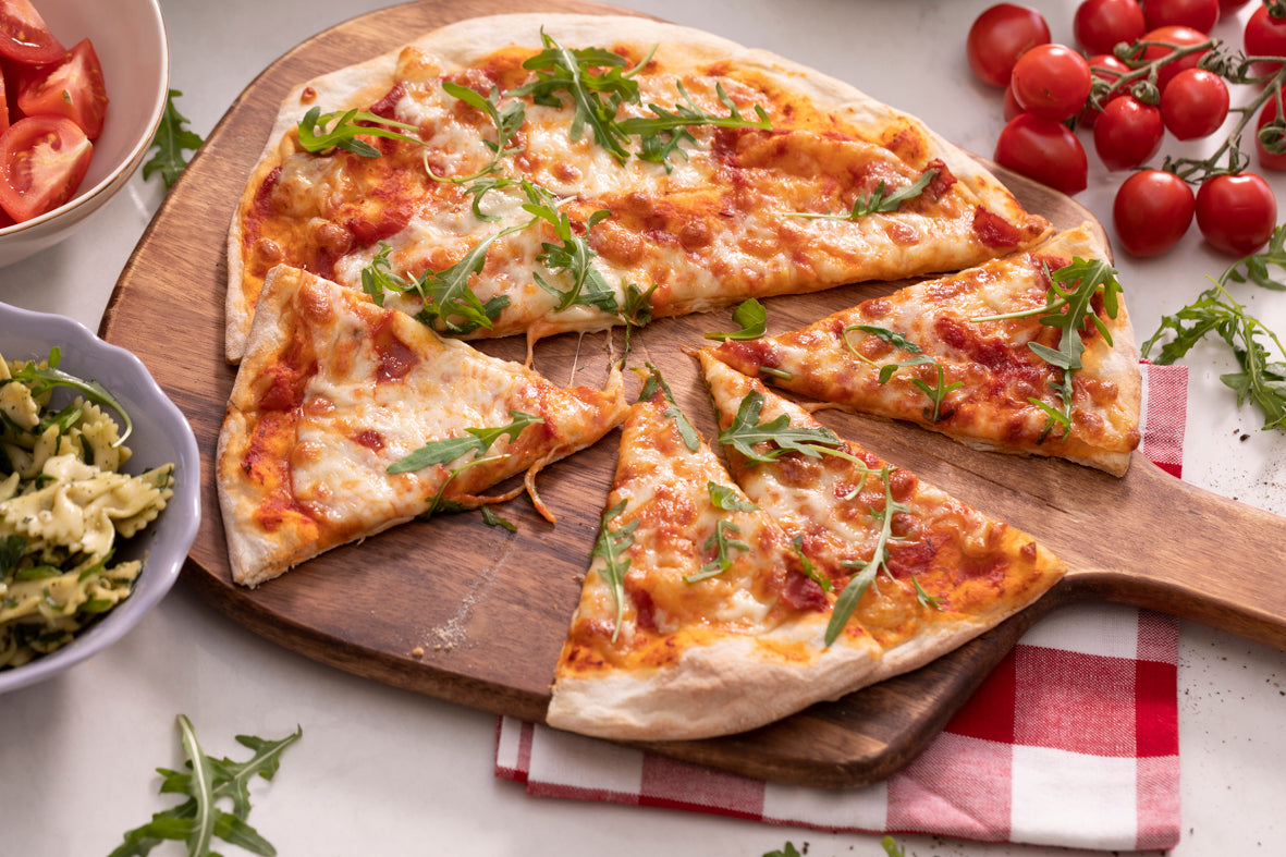 cooked pizza topped with mozzarella and rocket leaves