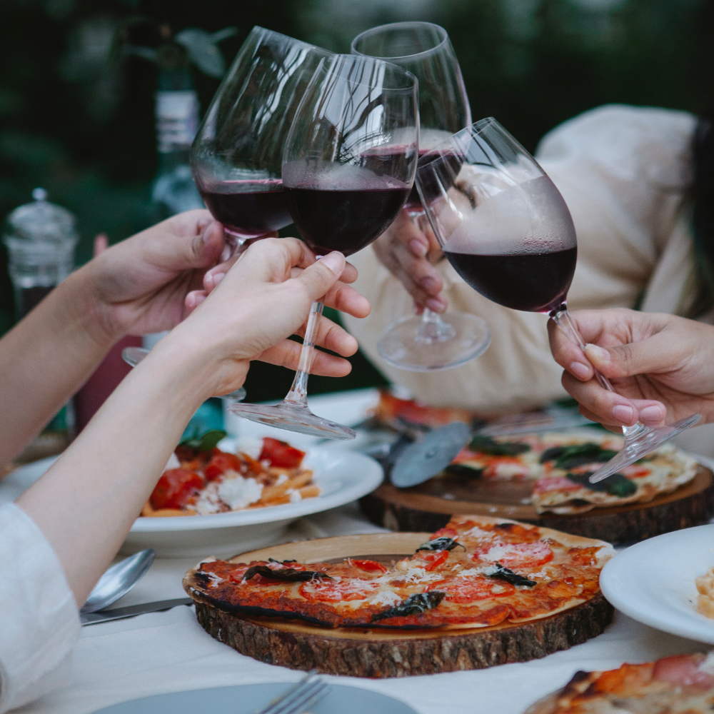 people eating pizza and drinking wine